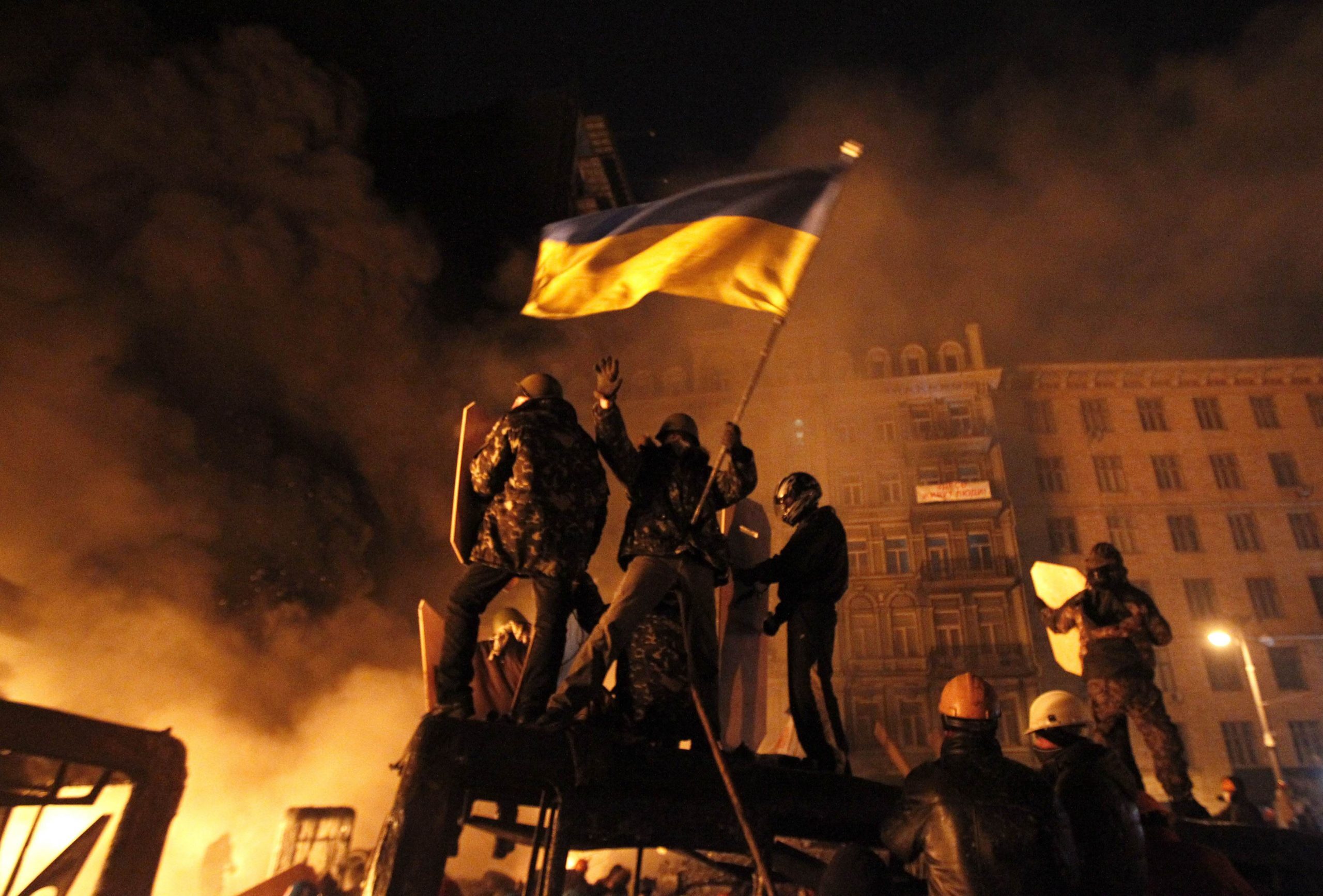 Anti-government protesters are seen at the site of clashes with riot police in Kiev