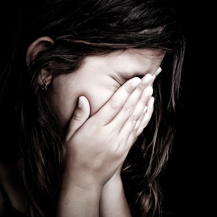Grunge portrait of a girl crying on a black background
