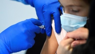 Children receive a flu vaccine in a military hospital