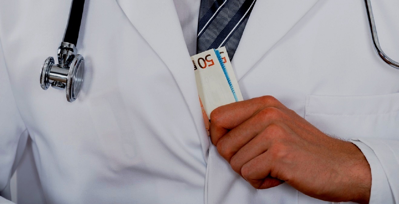 Close-up Of Male Doctor Hand Putting Money In Pocket
