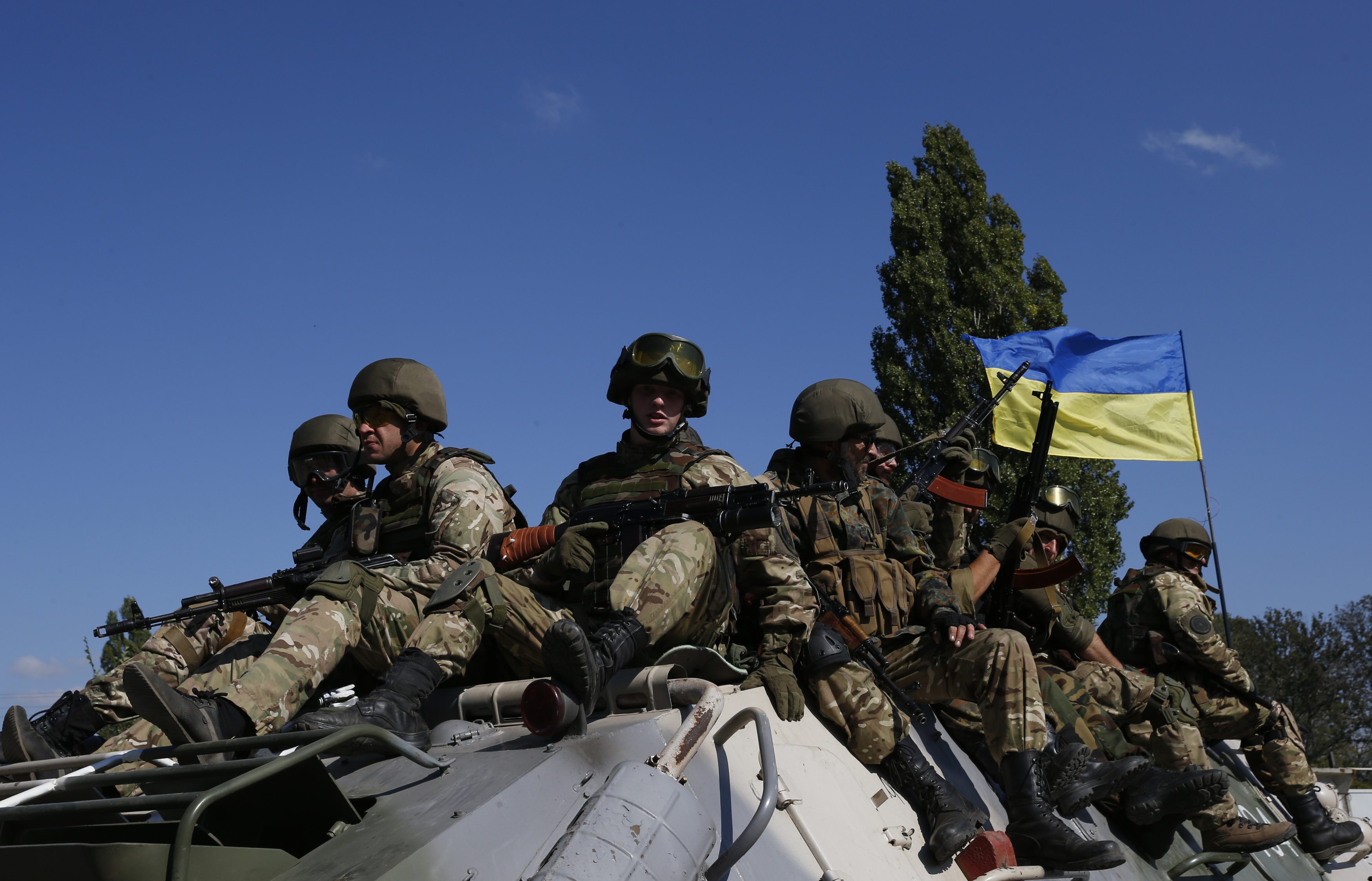 Ukrainian servicemen ride on an armoured vehicle near the eastern Ukrainian town of Pervomaysk