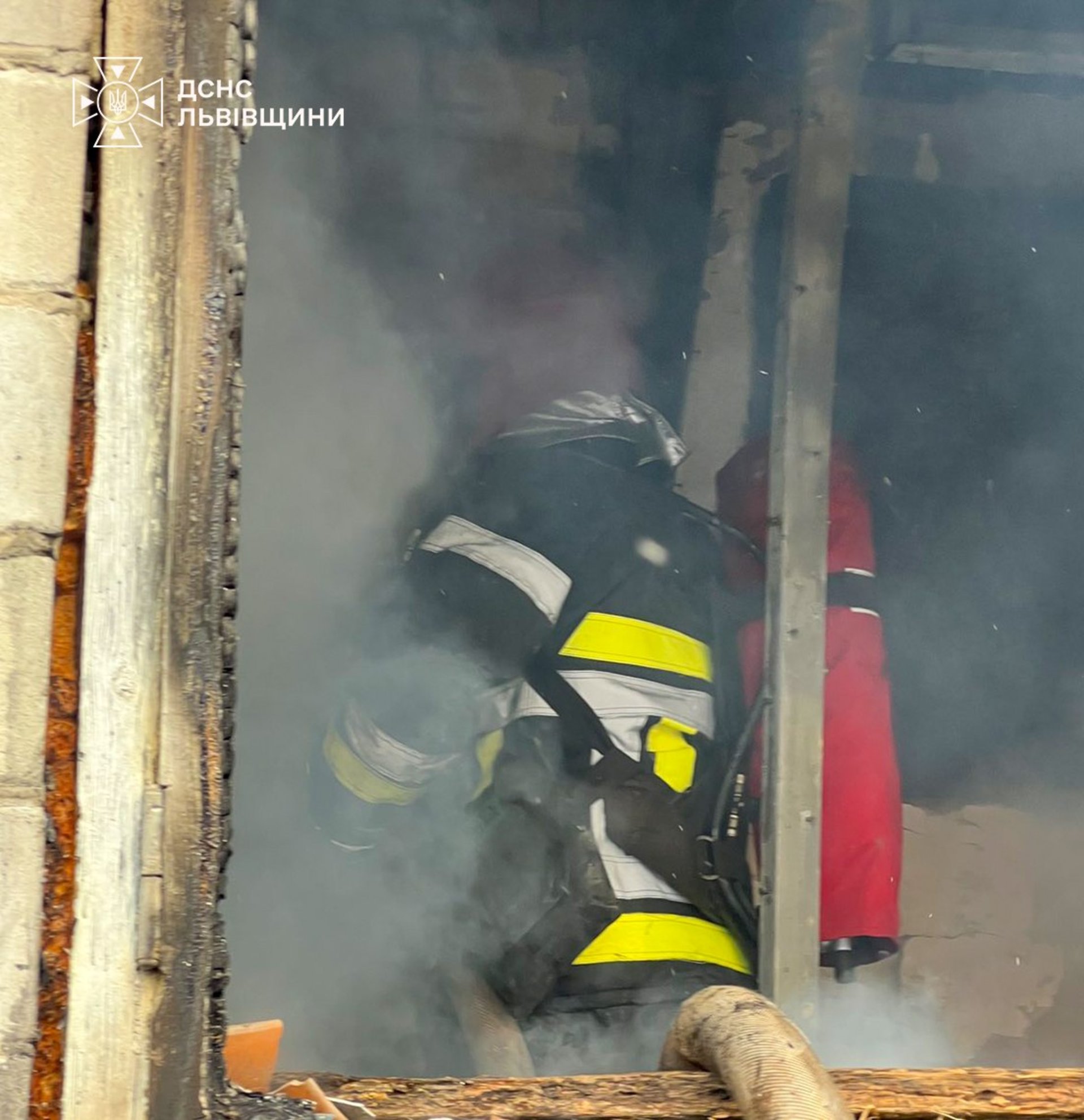 Фото: ДСНС Львівщини. Рятувальник гасить пожежу всередині житлового будинку в селі Бартатів.