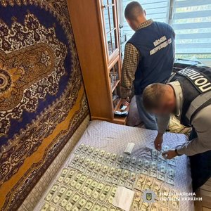 Фото: Національна поліція України. Під час обшуку вилучили готівку в доларах США.